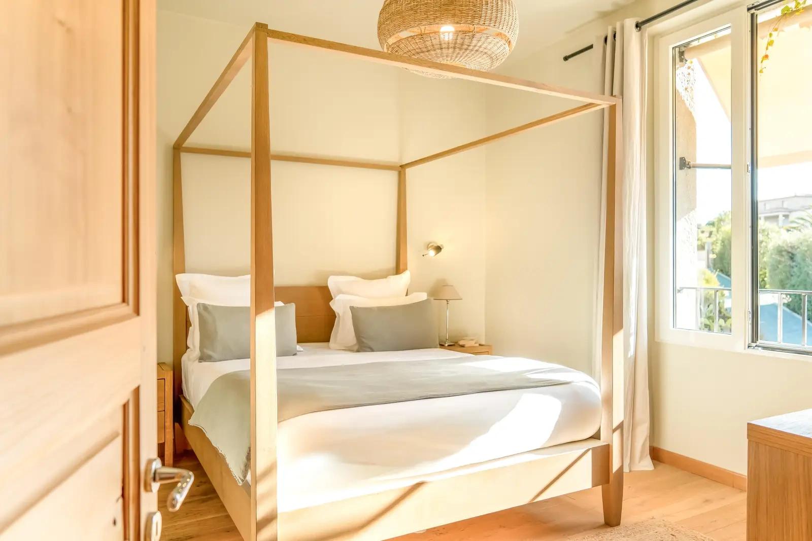 Chambre au lit à baldaquin, baignée de lumière